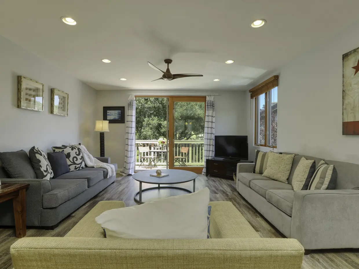 Living room at Avila Beach Gem with two gray sofas facing each other and doors onto the deck
